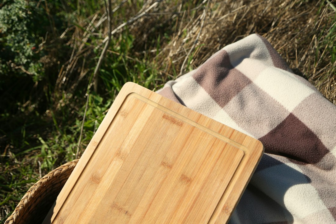 a wooden cutting board sitting on top of a blanket
